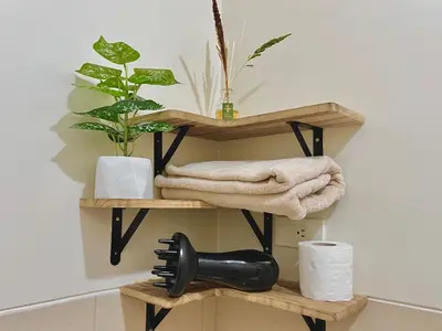 a black hair dryer on a wooden shelf in a bathroom at 1 Bedroom Condo Unit Near SM City Sucat and NAIA Terminal in Manila