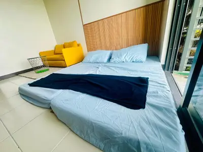 a large bed in a room with a yellow chair at Semi Furnished Condo at Sta Rosa Zadia Tower 2 in Sampong