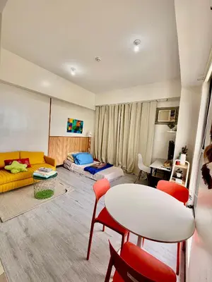 a living room with a couch and a table and chairs at Semi Furnished Condo at Sta Rosa Zadia Tower 2 in Sampong