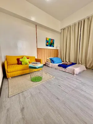 a living room with a couch and a bed at Semi Furnished Condo at Sta Rosa Zadia Tower 2 in Sampong