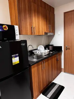 a kitchen with a sink and a black refrigerator at AR Pahinga Place - The Pause House in Manila