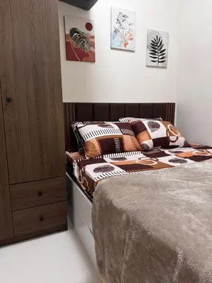a bedroom with a bed and a wooden cabinet at AR Pahinga Place - The Pause House in Manila