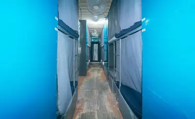 an empty hallway with blue walls and a long corridor at CitiHub Shaw Santa Mesa in Manila