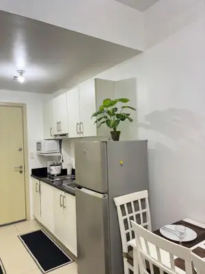 a kitchen with a stainless steel refrigerator and a table at Jazz Luxe Getaway in Manila