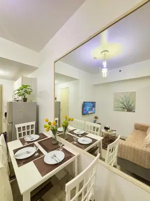 a dining room and living room with a table and chairs at Jazz Luxe Getaway in Manila
