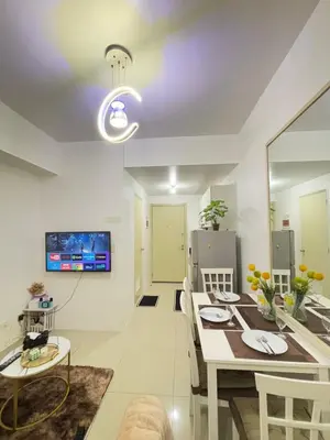 a dining room with a table and a tv on the wall at Jazz Luxe Getaway in Manila