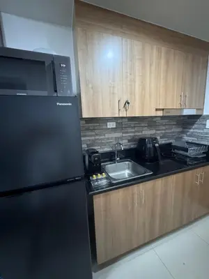 a kitchen with a black refrigerator and a sink at Kaizen cozy and comfortable condo at Red Residences Makati in Manila
