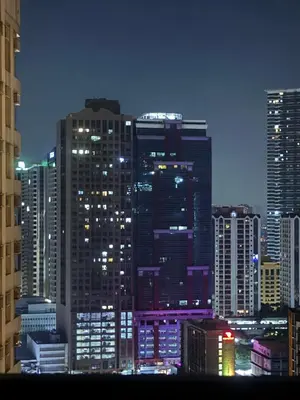 a city skyline at night with many tall buildings at Kaizen cozy and comfortable condo at Red Residences Makati in Manila