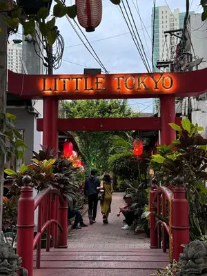 a red sign that reads little tokyo on a sidewalk at Kaizen cozy and comfortable condo at Red Residences Makati in Manila