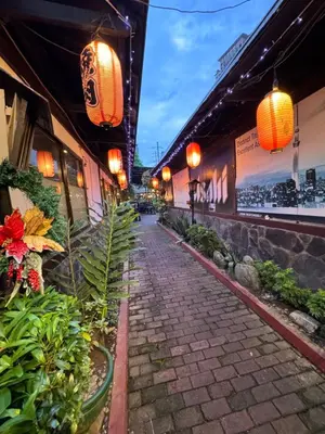 a cobblestone walkway with lanterns and plants in a building at Kaizen cozy and comfortable condo at Red Residences Makati in Manila
