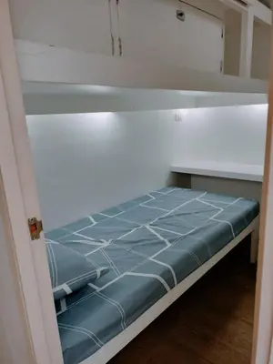 a bed with blue sheets in a room at Nemar Building Solo Room w AC in Manila