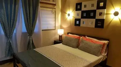a bedroom with a bed with pillows and a window at 1 BR Luxury Apartment in Manila