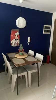 a dining room table with white chairs and a blue wall at 1 BR Luxury Apartment in Manila