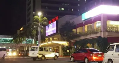 a city street with cars parked in front of a building at 1 BR Luxury Apartment in Manila