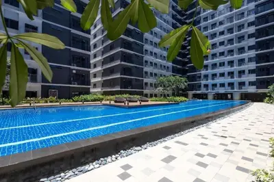 a swimming pool in a building with tall buildings at Cozy Modern Condotel in Pasay Near MOA & Airport in Manila