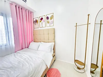 a small bedroom with a bed and pink curtains at Cozy Modern Condotel in Pasay Near MOA & Airport in Manila