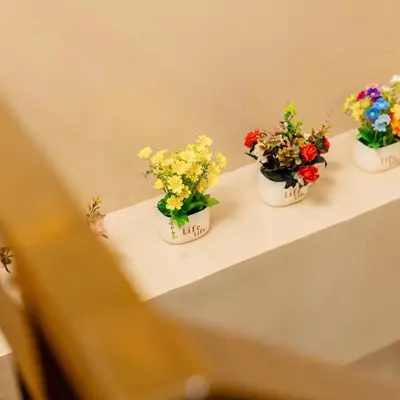 three potted flowers sitting on a table at Atman Suite 2 BR 2 Bathroom Fort Victoria BGC Taguig in Manila
