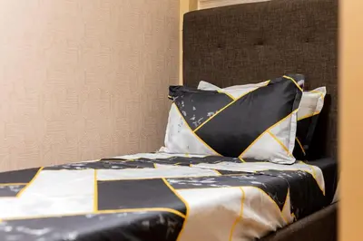 a bed with black and white sheets and pillows at Atman Suite 2 BR 2 Bathroom Fort Victoria BGC Taguig in Manila