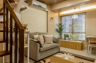 a living room with a couch and a window at Atman Suite 2 BR 2 Bathroom Fort Victoria BGC Taguig in Manila