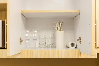 a shelf with glasses and utensils on it at Atman Suite 2 BR 2 Bathroom Fort Victoria BGC Taguig in Manila