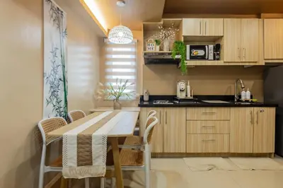 a kitchen with a table and chairs and a sink at Atman Suite 2 BR 2 Bathroom Fort Victoria BGC Taguig in Manila