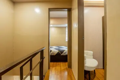a hallway with a bedroom with a bed and a mirror at Atman Suite 2 BR 2 Bathroom Fort Victoria BGC Taguig in Manila