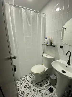 a white bathroom with a toilet and a sink at San Lorenzo Place Condominium Makati City in Manila