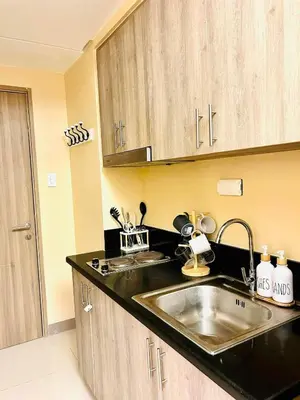 a kitchen with a sink and a counter top at Staycation in Diamond in Manila