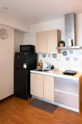 a kitchen with a black refrigerator and a sink at Staycation in Diamond in Manila