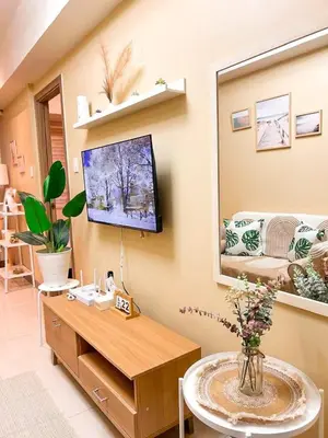 a living room with a tv on the wall at Staycation in Diamond in Manila