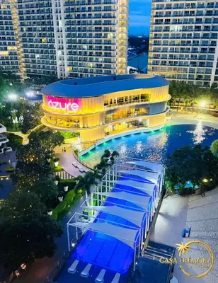 a large building with a swimming pool at night at Azure Staycation by Casa Tremora in Manila