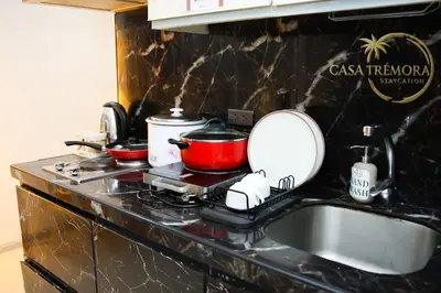 a kitchen counter with a sink and a mirror at Azure Staycation by Casa Tremora in Manila