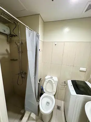 a bathroom with a toilet and a shower and a sink at Kathys Crib 11th flr 2 at Shell Residence pool view in Manila
