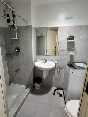 a bathroom with a sink and a shower and a toilet at Sea Residence Condotel Pasay in Manila