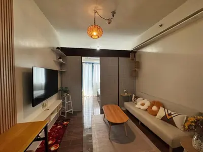 a living room with a couch and a tv at Condo in Makati in Manila
