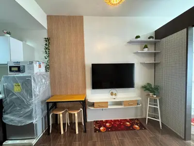 a living room with a television and a table and stools at Condo in Makati in Manila