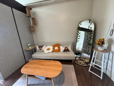 a room with a couch with a table and a mirror at Condo in Makati in Manila