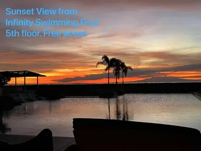 a sunset over a body of water with palm trees at Luxurious Modern 2 Bedrooms Facing Manila Bay Sunset, Airports, Okada, Solaire, MOA with free parking in Manila
