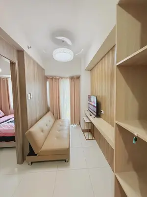 a room with a couch and a bed and a television at Cozy Minimalist Staycation in Manila