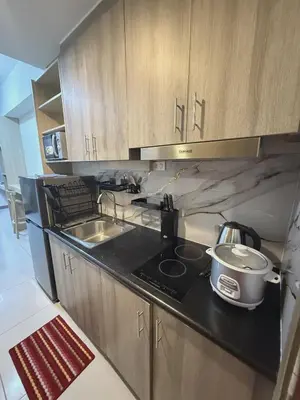 a small kitchen with a stove and a sink at Cozy Minimalist Staycation in Manila