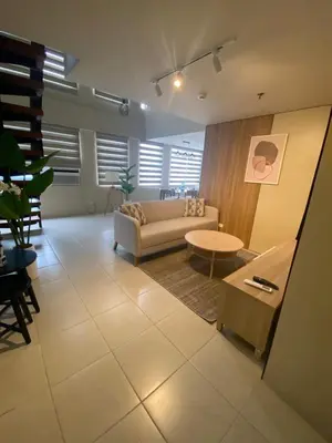 a living room with a couch and a table at EDSA Heights Ama Tower Unit 3305 Loft Penthouse Unit in Manila