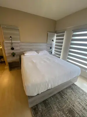 a bedroom with a white bed and two windows at EDSA Heights Ama Tower Unit 3305 Loft Penthouse Unit in Manila