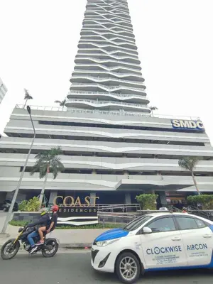 a cop car and a man on a motorcycle next to a building at Horizon Haven in Manila