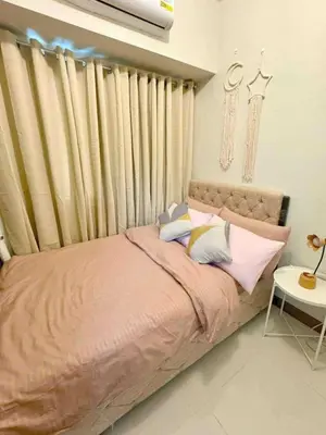 a bedroom with a bed with pillows on it at Horizon Haven in Manila