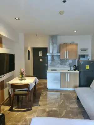 a living room with a table and a kitchen at Condominium unit Knightsbridge Residences, Makati in Manila