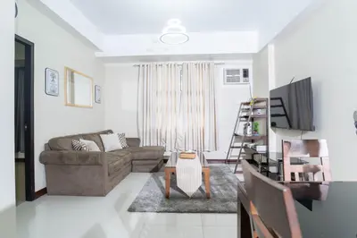 a living room with a couch and a table at 101 Newport Boulevard 1BR with Parking - Pasay City in Manila