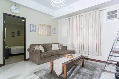 a living room with a couch and a table at 101 Newport Boulevard 1BR with Parking - Pasay City in Manila