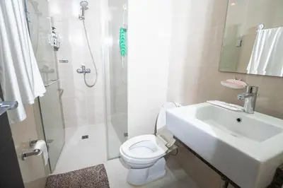 a bathroom with a sink and a toilet and a shower at 101 Newport Boulevard 1BR with Parking - Pasay City in Manila