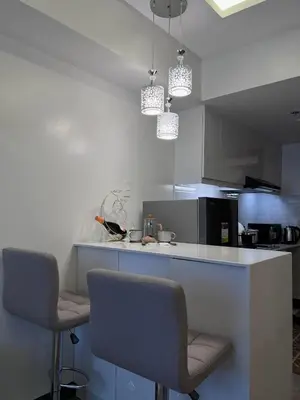 a kitchen with two chairs and a counter top at Staycation at JG in Manila