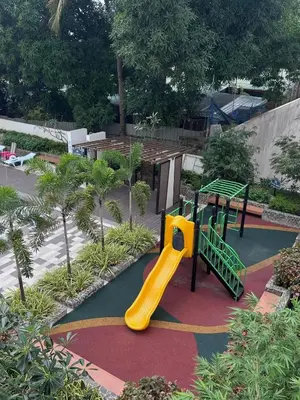 a playground with a yellow slide in a park at Staycation at JG in Manila